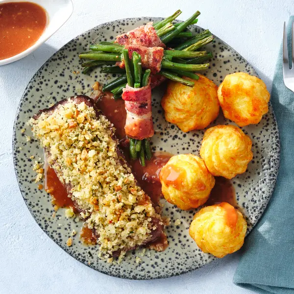 Lammlachs in Kräuterkruste mit Speckbohnen und Herzogin-Kroketten