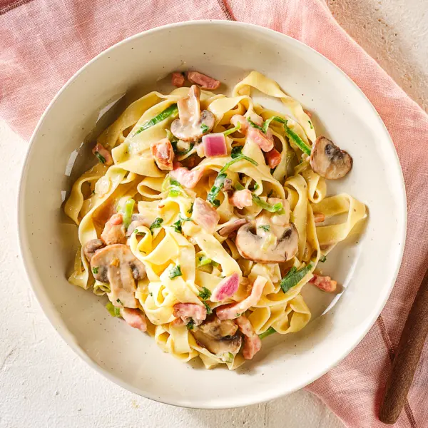 Cremige Tagliatelle mit Champignons und Speck