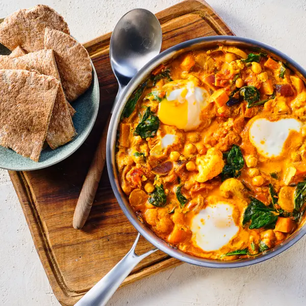 Mildes Tomatencurry mit pochierten Eiern