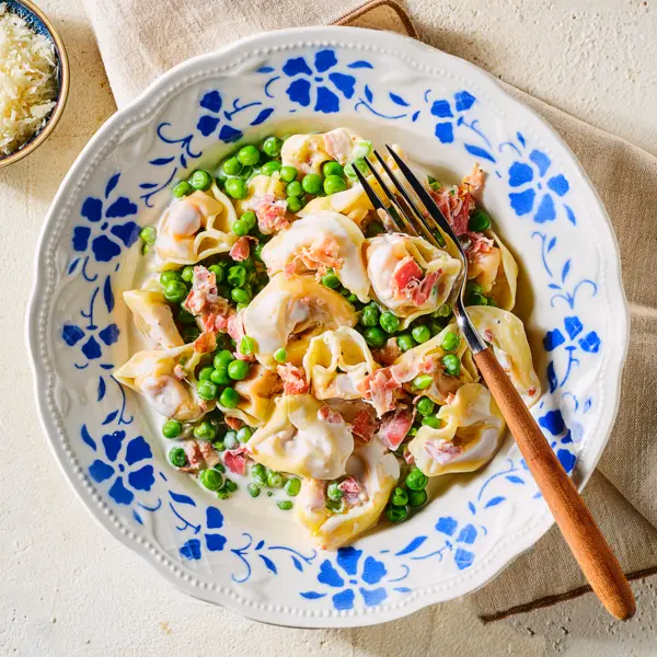 Cremige Tortelloni mit Erbsen und Schinken