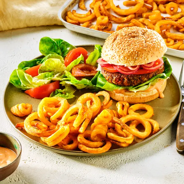 Vegetarischer Burger mit Curly Fries und Salat